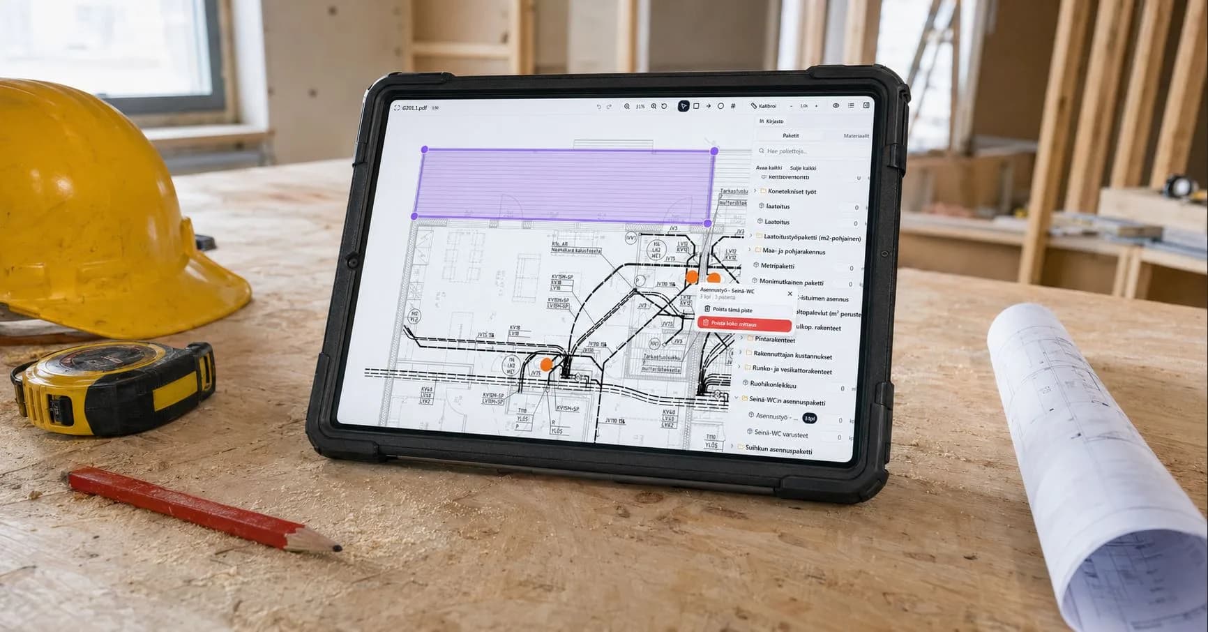 FiSAS käytössä tabletilla rakennustyömaalla piirustusten ja työvälineiden keskellä
